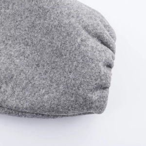 Macro detail of grey wool texture and stitching on a soft pilot jacket for women