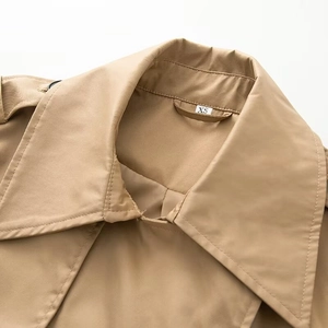 Cropped shot of khaki double-breasted trench coat featuring classic lapel and fine stitching