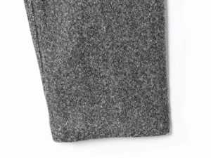 Close-up of premium gray wool fabric texture and stitching detail on jacket sleeve