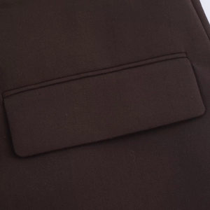 Detailed view of flap pocket on dark brown oversized blazer with quality stitching