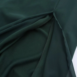 Detailed macro shot of dark green mesh fabric texture and stitching on the dress