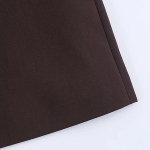 Detail shot of high-quality dark brown twill fabric with precision stitching on the hem
