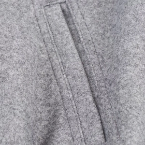 Macro shot of double-row parallel stitching on grey wool blend bomber jacket fabric