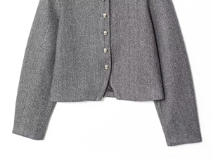 Close-up of grey wool blend jacket featuring decorative silver metal buttons and texture
