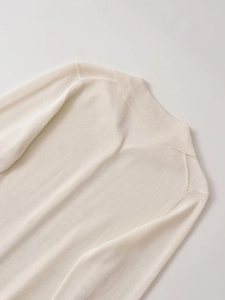 Detailed view of the ribbed polo collar and soft knit texture on cream cardigan