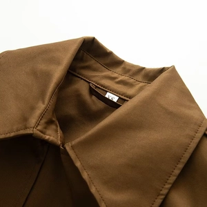 Close-up of lapel collar and XS size label on brown double-breasted trench coat