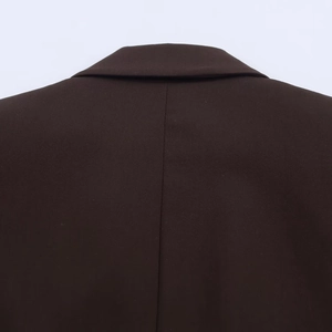 Detail of high-quality woven fabric and reinforced back seam on dark brown blazer