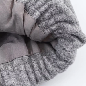Macro shot showing grey wool blend fabric texture and smooth satin lining of the bomber jacket