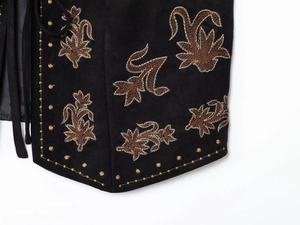 Détail de la broderie florale marron sur le tissu noir effet daim du gilet