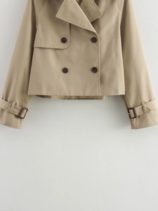 Detail of khaki cropped trench coat showing double-breasted buttons and adjustable cuffs