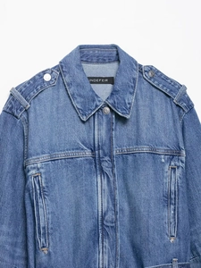 Close-up of light blue denim jacket featuring classic lapel collar and brand neck label