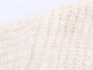 Macro shot of cream oversized knit cardigan showing detailed soft wool texture