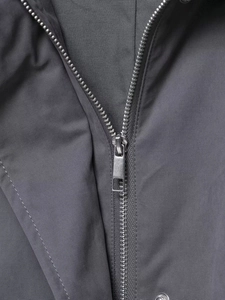 Detailed macro view of the smooth metal zipper on dark gray functional jacket fabric