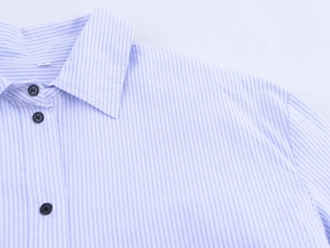 Detail of blue and white striped poplin shirt showing collar and black buttons