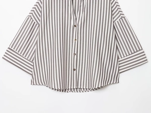 Detail of gray and white vertical stripes on loose linen shirt with resin buttons