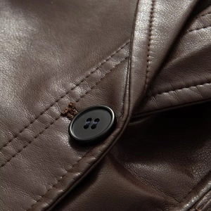 Detailed close-up of dark brown faux leather jacket with high-quality buttons and stitching