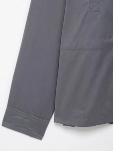 Detailed close-up of charcoal grey utility jacket sleeve with visible stitching and texture