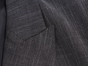 Close-up of black and white textured woven fabric on double-breasted blazer lapel