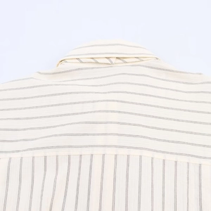 Détail d'une chemise beige à rayures montrant l'empiècement arrière et le tissu