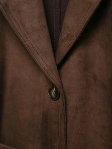 Détail de la veste en suédine marron avec col à revers et bouton à motif écailles de tortue