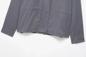 Detail of dark grey utility jacket with symmetric large pockets and reinforced stitching