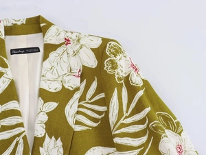 Detailed close-up of linen blend floral print blazer with olive green and red flower patterns