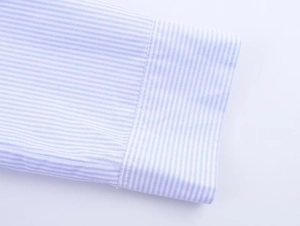 Detailed macro view of the striped cotton shirt cuff with fine white and blue patterns