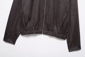 Detail of dark brown faux suede jacket with metal zipper and elastic hemline finish