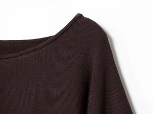 Detail of off-the-shoulder neckline on dark brown loose knit top with fine texture