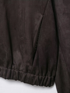 Detail view of the suede jacket showing the elastic hem and the side seam pocket design