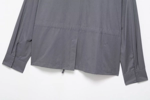 Close-up of deep gray hooded jacket showing smooth fabric texture and back slit stitching detail