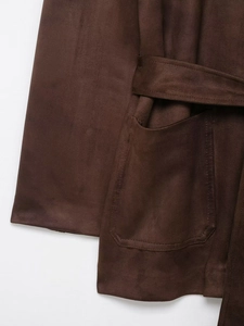 Détail d'une veste en daim marron avec grande poche plaquée et ceinture assortie