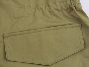Detailed close-up of khaki parka jacket with large pocket flap and reinforced stitching