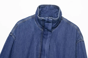 Detailed macro view of dark blue denim jacket fabric texture and seamless stitching