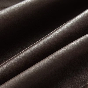 Close-up of deep brown faux leather with detailed litchi grain texture and natural sheen