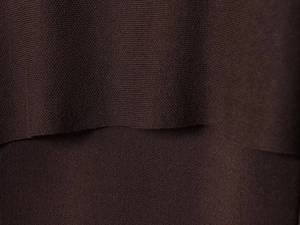Macro detail of dark brown knit fabric showing fine texture and layered seam structure