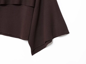 Macro view of dark brown knit fabric showing the asymmetrical hem and fine texture