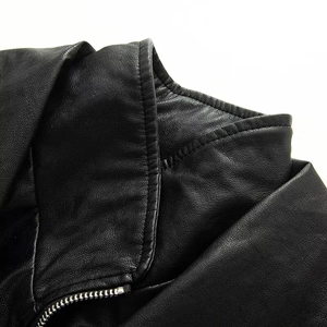 Detail of double-layer collar and metallic zipper on high-quality black faux leather jacket