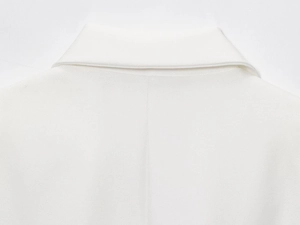 Détail du col d'un blazer blanc en lin mélangé montrant la texture du tissu tissé