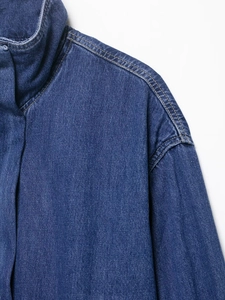 Detail of dark blue denim jacket collar featuring yellow topstitching and dropped shoulders