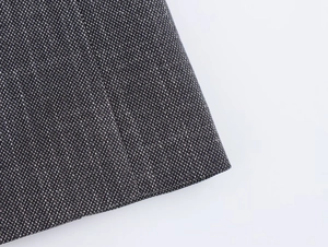 Macro shot of black and white tweed fabric texture for shoulder-padded blazer