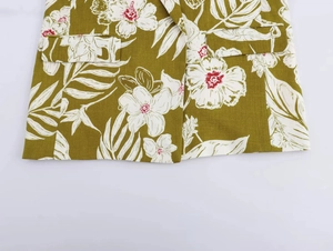 Detail of floral print blazer featuring olive green fabric and symmetrical flap pockets