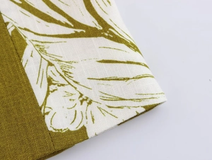Detail of linen blend fabric showing olive green textile and leaf print with stitching