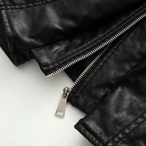Detail shot of black faux leather texture with premium silver metal zipper and stitching