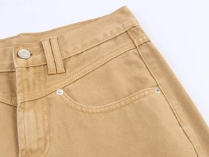 Detailed macro view of khaki twill pants featuring metal button and reinforced pockets