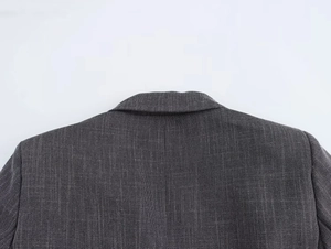 Detail of shoulder tailoring and padded construction on dark grey double-breasted blazer