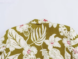 Close-up of tropical floral print on olive green linen blend blazer with white hibiscus