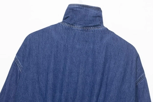Detail of stand-up collar and dropped shoulder seams on dark blue washed denim jacket