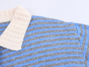 Close-up of blue and gray striped knit cardigan featuring a textured cream collar