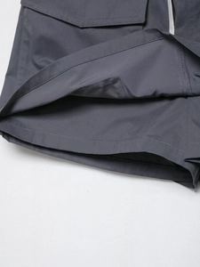 Detailed view of reinforced double stitching and drawstring pocket on grey cargo shorts